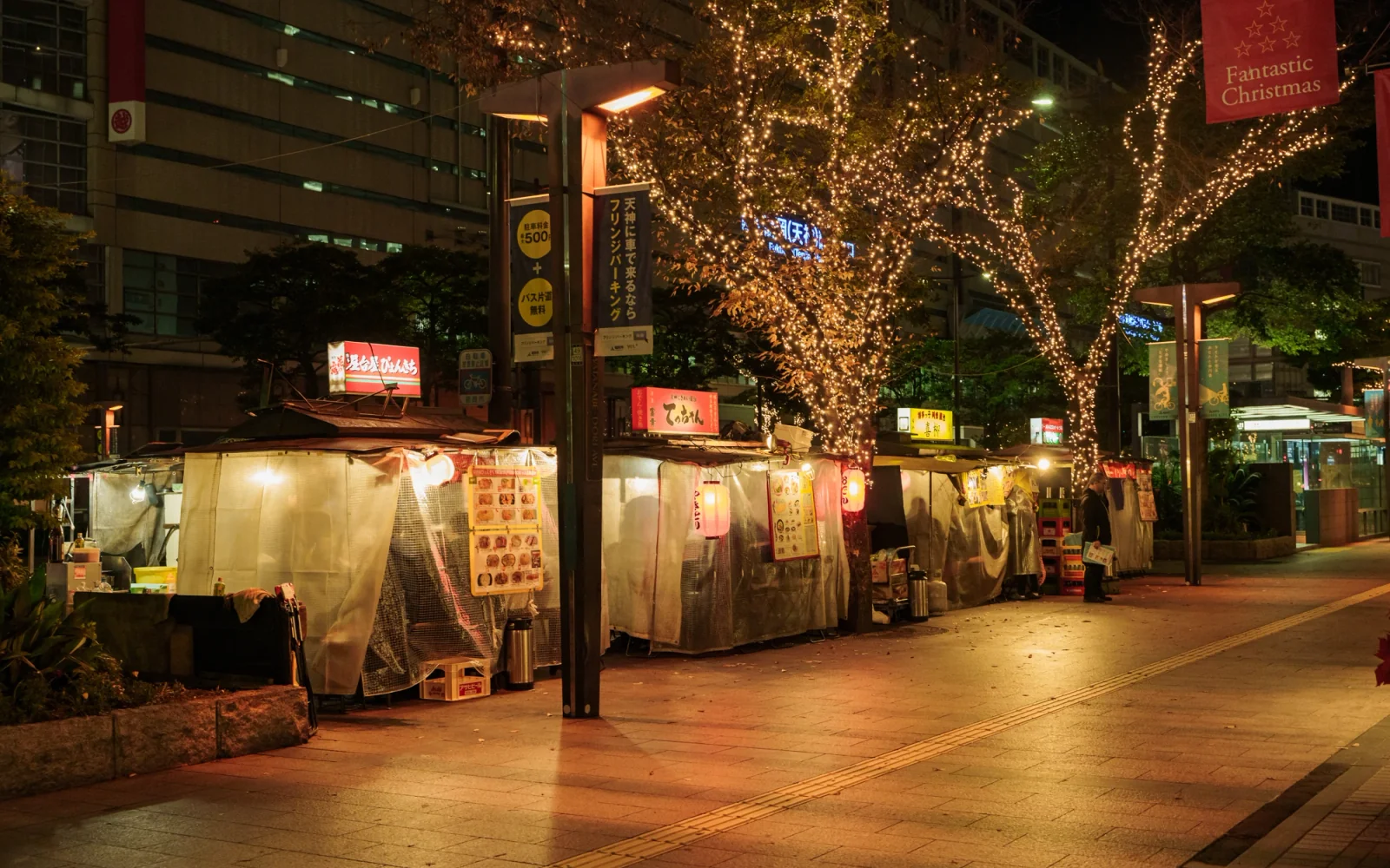Street-level Yatai stalls glowing with lanterns on Watanabe-dori avenue in Tenjin Fukuoka at night
