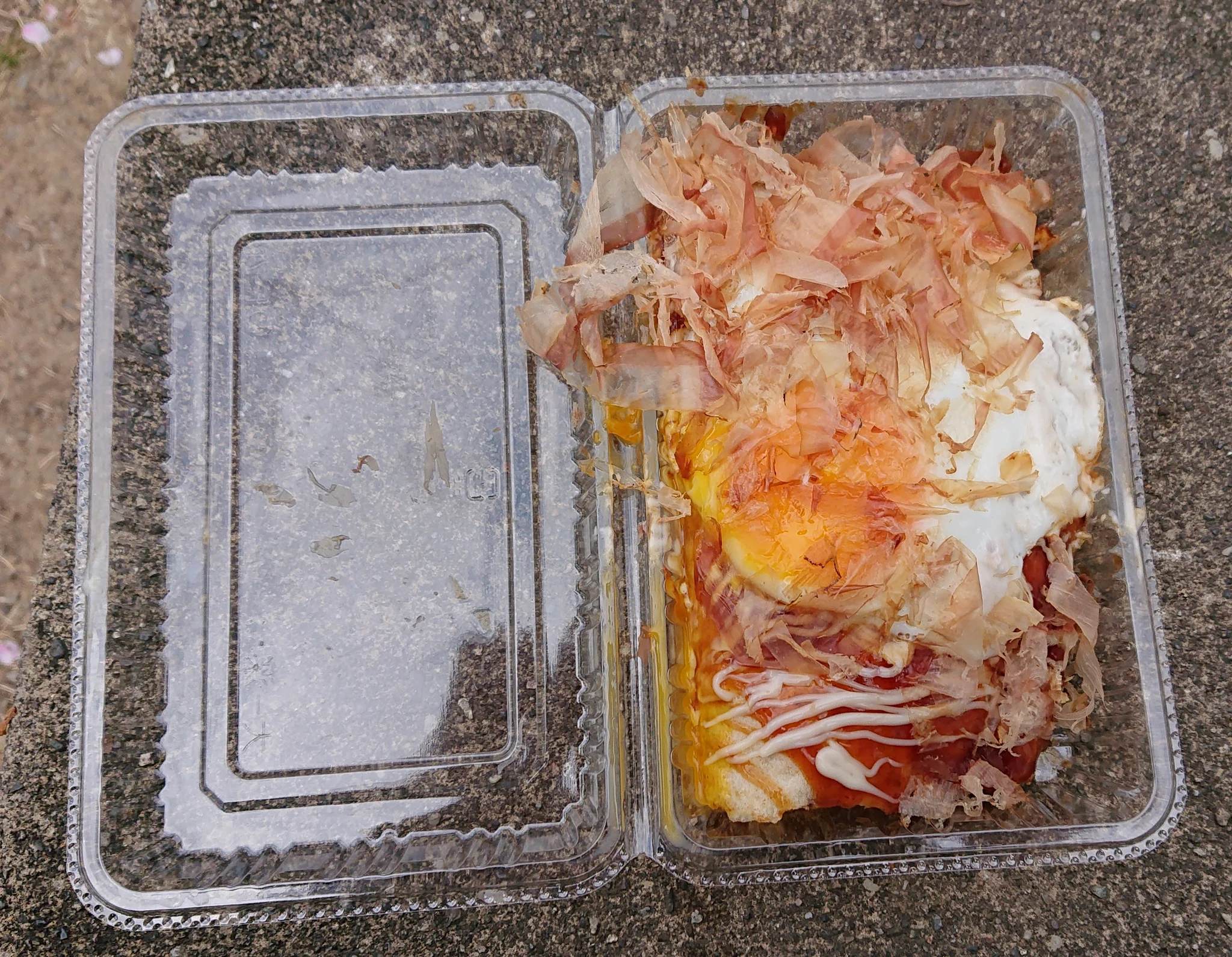 Master chef pressing multi-layered Hiroshima okonomiyaki on a heavy steel teppan griddle