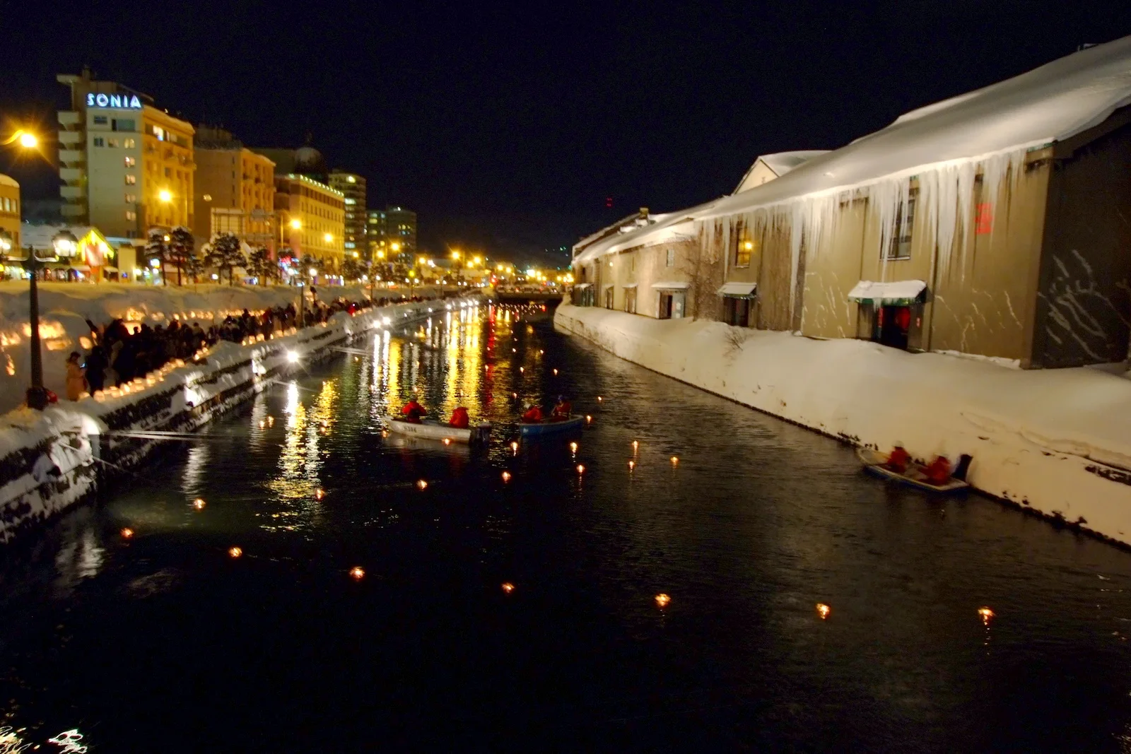 Candlelight glowing softly on snow-covered banks during Otaru Snow Light Path Festival