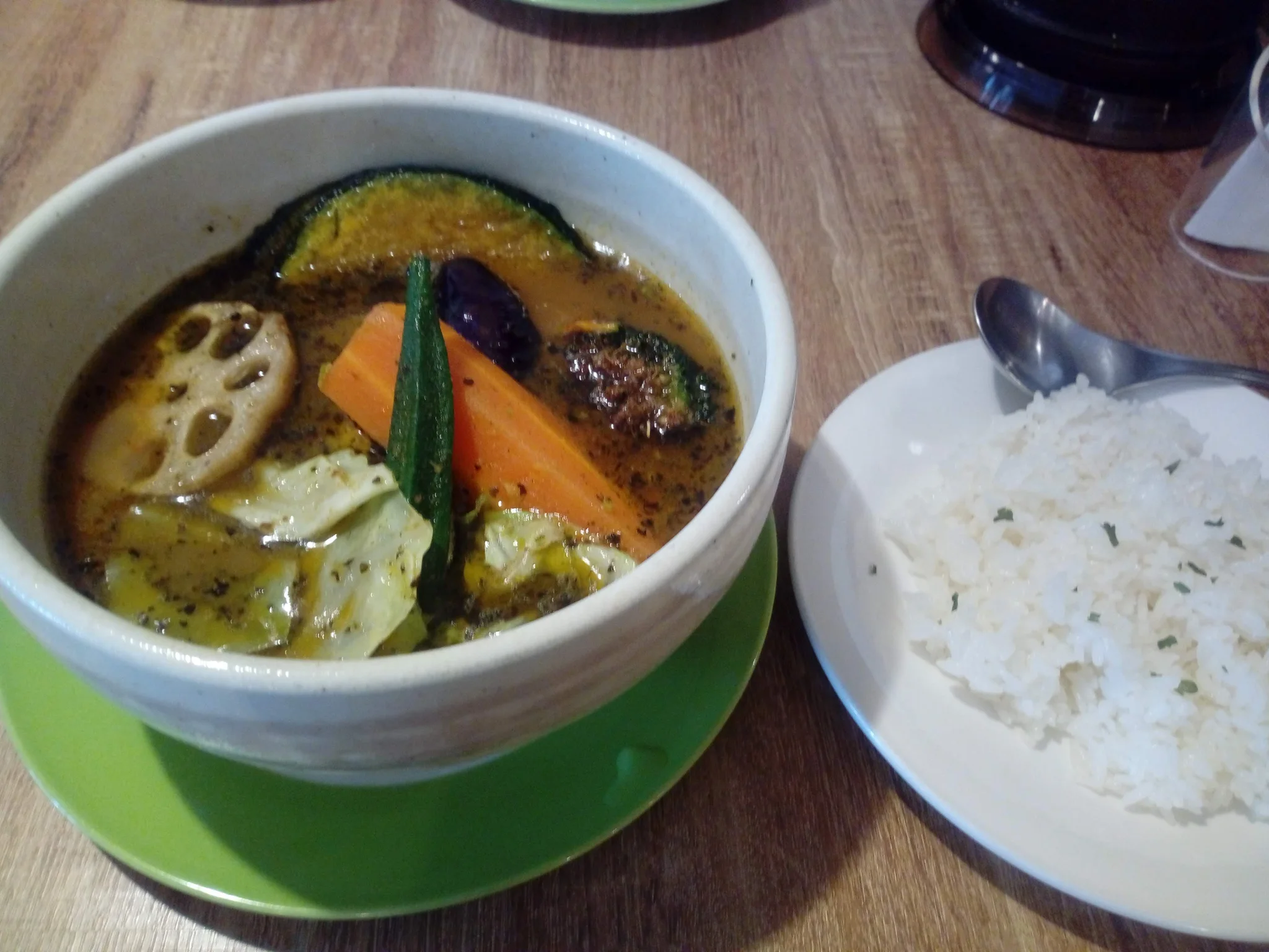 Rich aromatic Sapporo soup curry bowl laden with deep-fried seasonal vegetables and fall-off-the-bone chicken leg