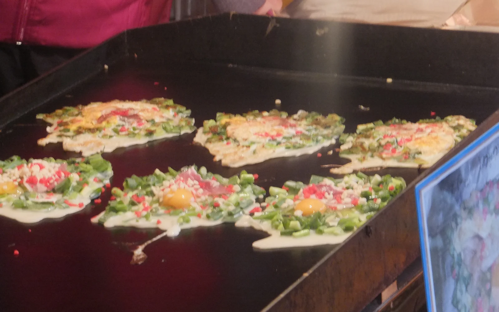 Savory negiyaki savory pancake packed with vibrant green Kujo scallions and soy-sauce lemon glaze on a teppan grill