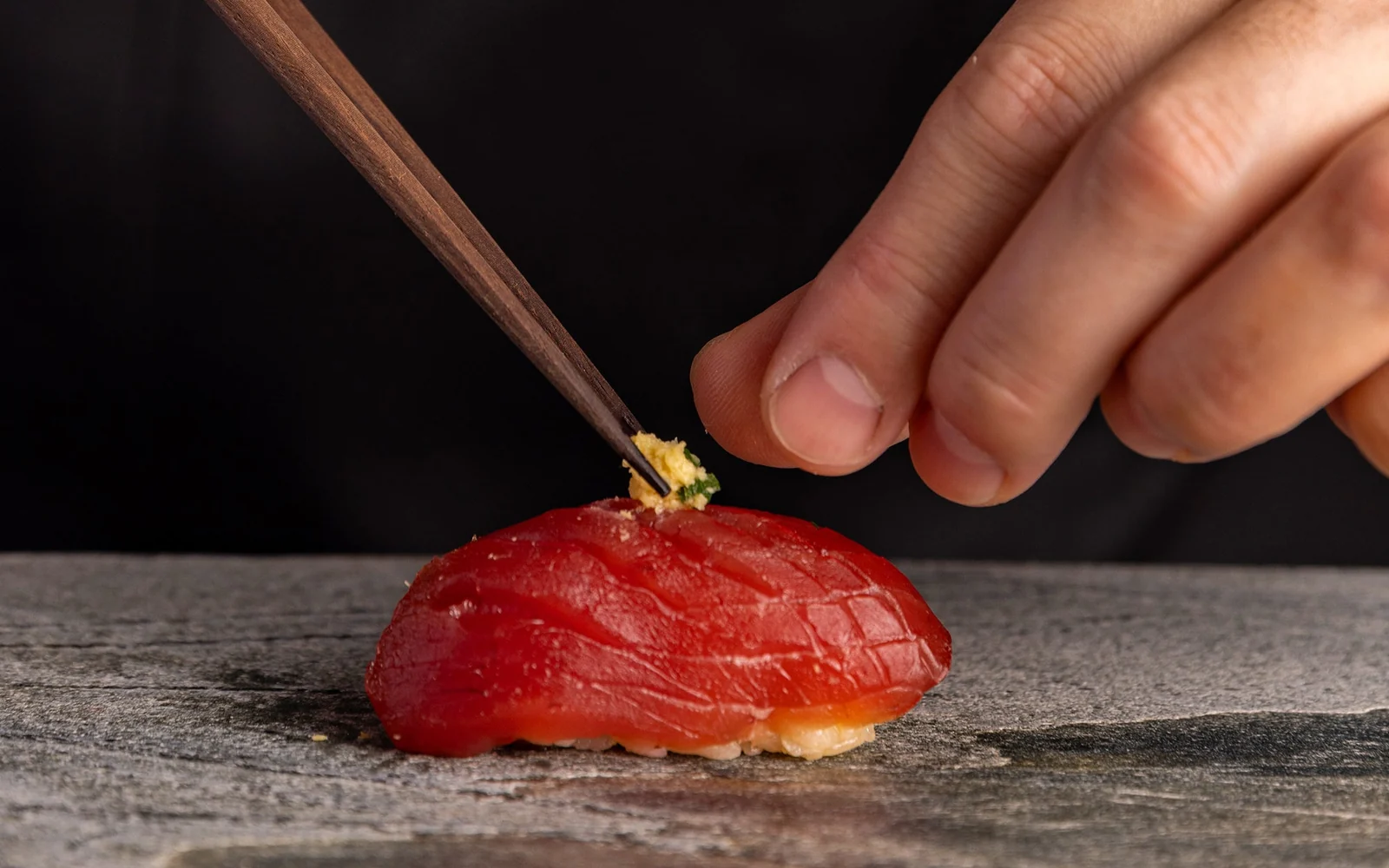 Master artisan Edomae sushi omakase nigiri course arranged on black urushi lacquer plinth at Ginza counter