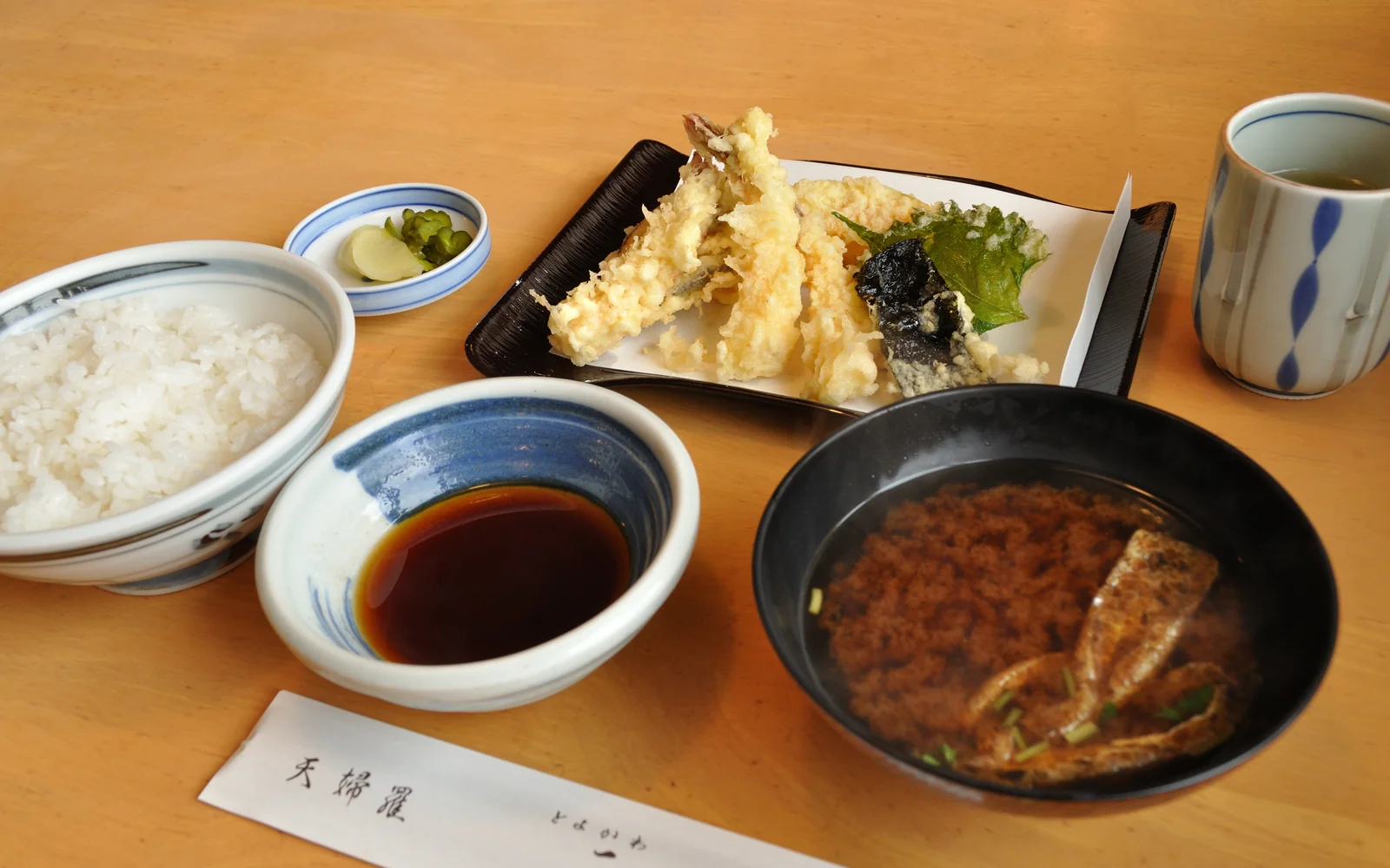Artisan Tokyo tempura omakase assortment served on traditional washi paper with tentsuyu broth and condiments
