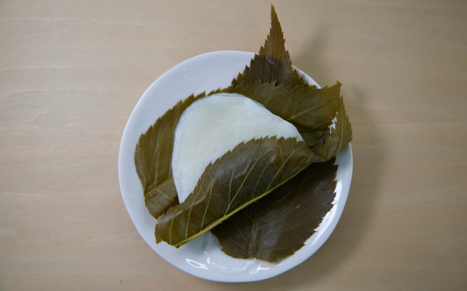 Authentic Tokyo Chomeiji Sakuramochi wrapped in salted Oshima cherry leaves beside spring sweets